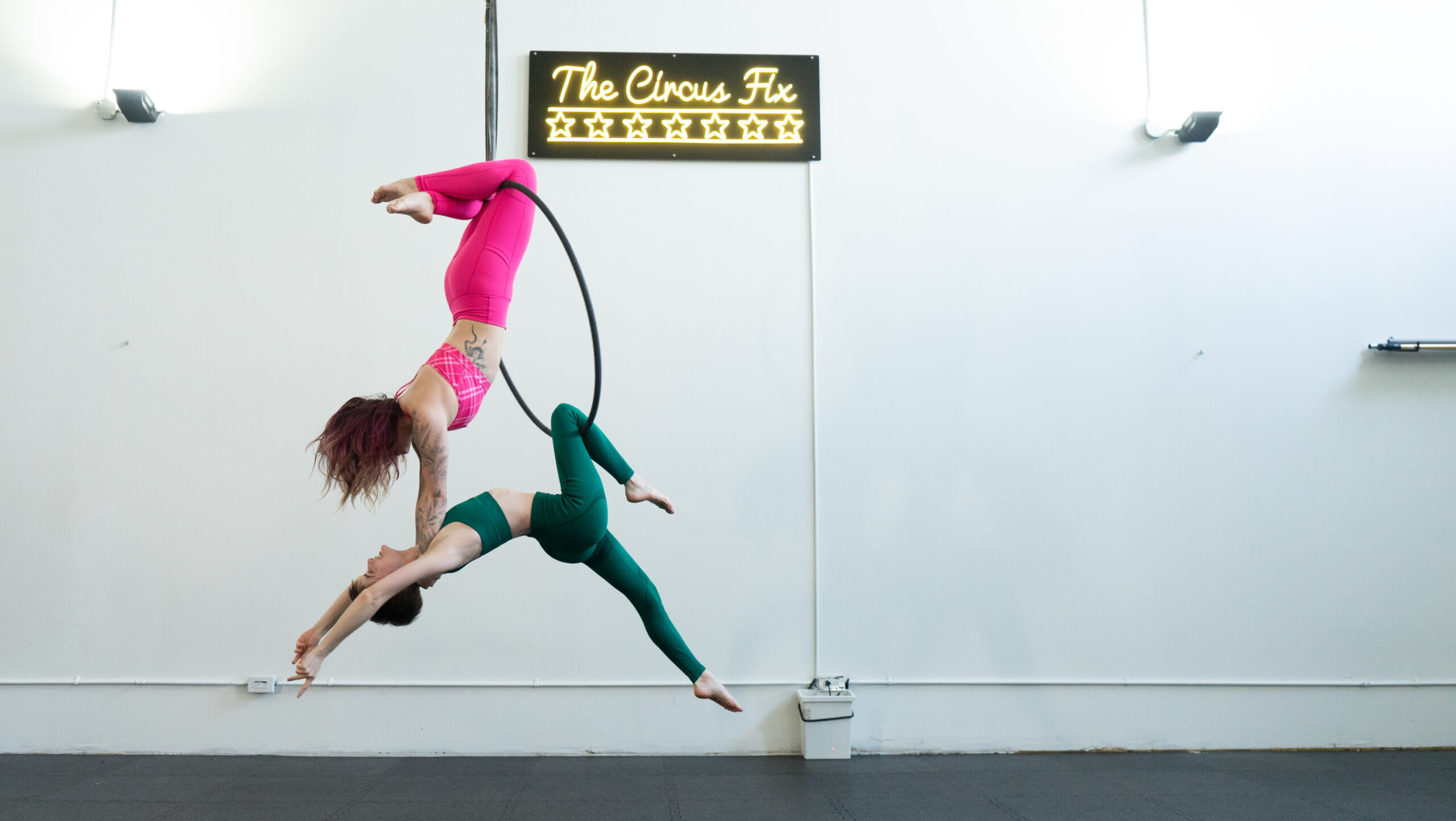 Two people playing in an aerial hoop at Circus Fix in Toronto