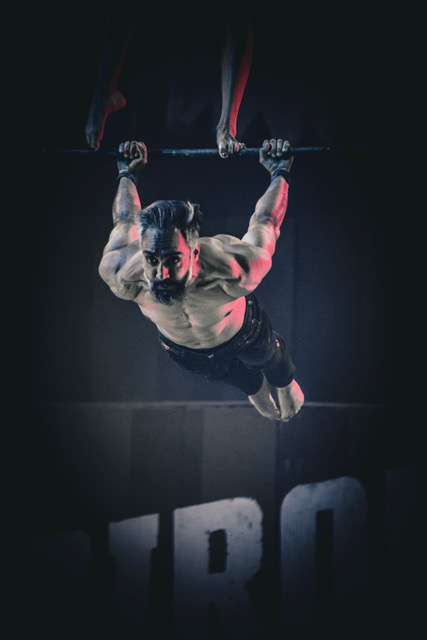Photo of a man hanging from the trapeze.