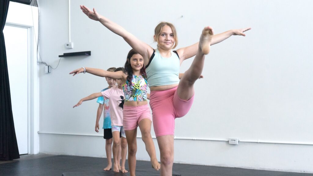 4 young people in a line. The first is doing a kick during drop in for youth/teens