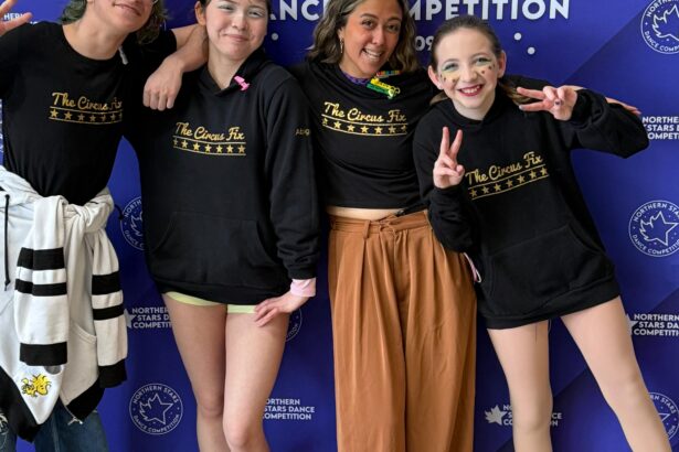 Happy competition team in front of sign